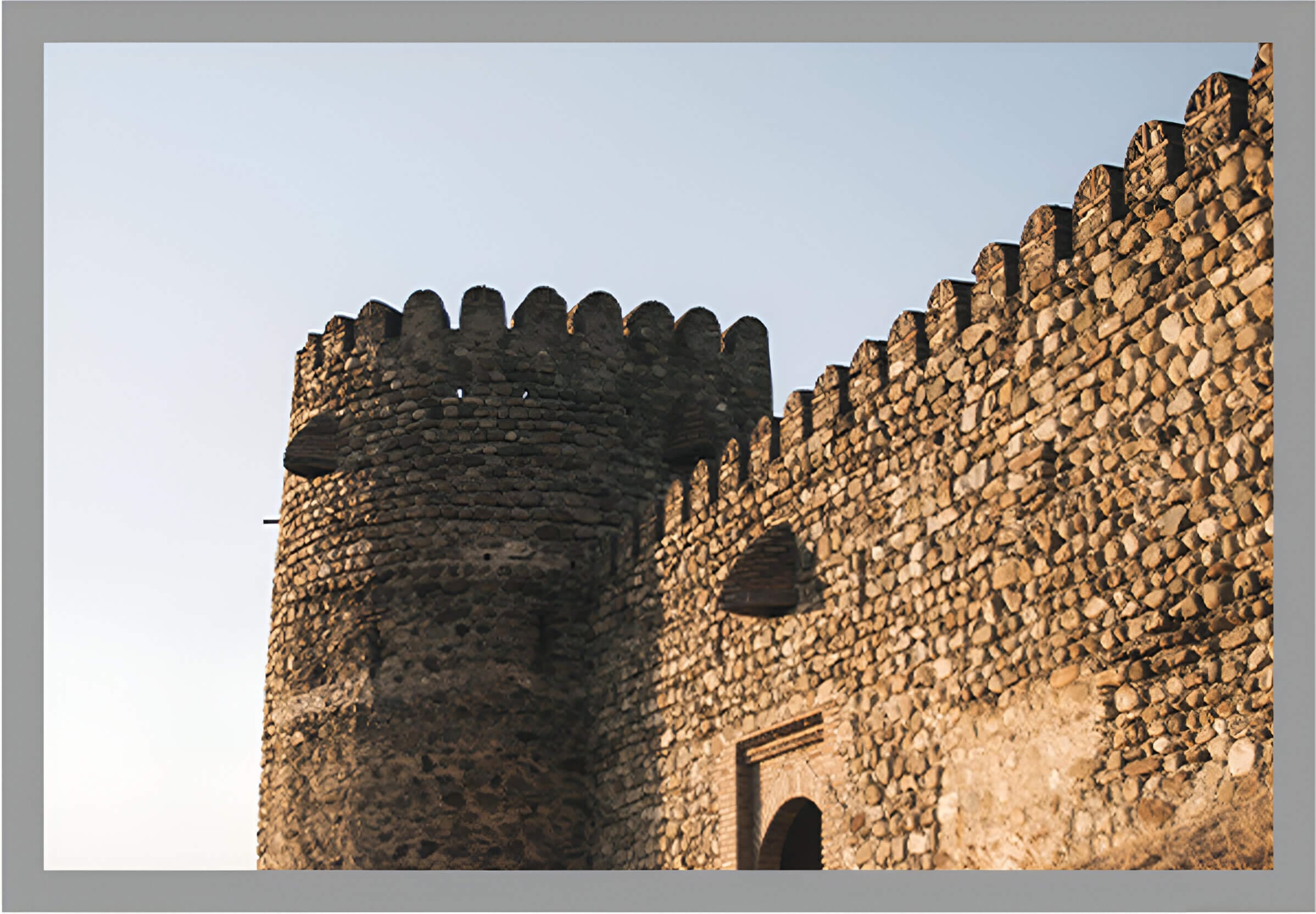 A stone castle with two towers and a door.