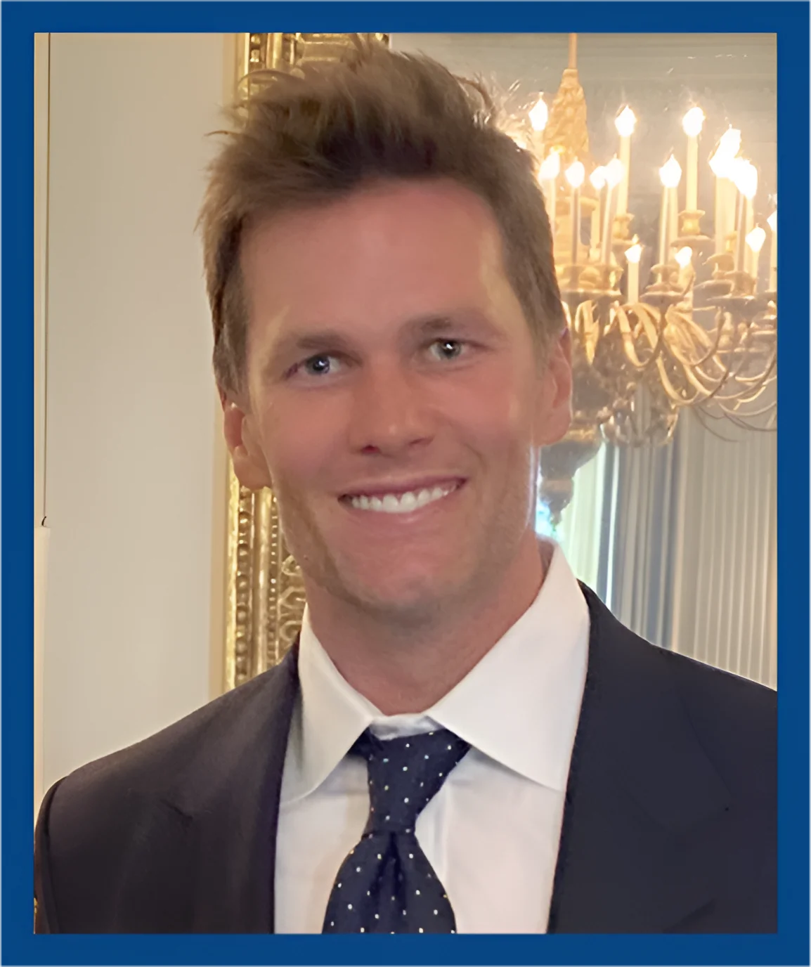 A man in suit and tie smiling for the camera.