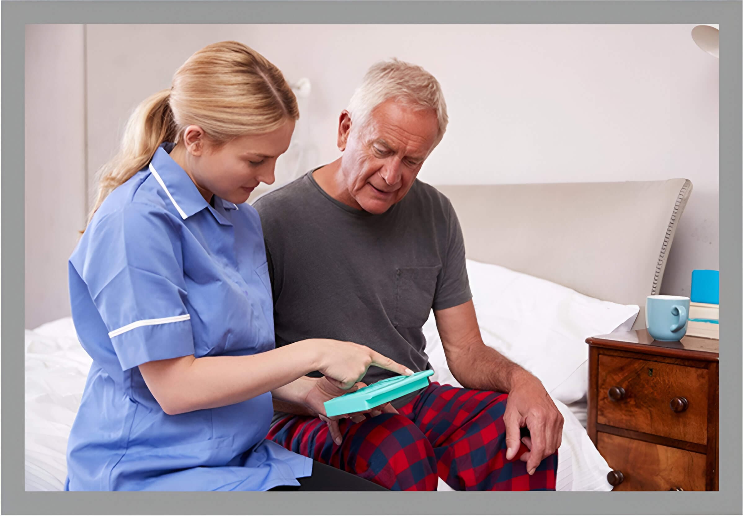 A nurse showing an elderly man something on his tablet.